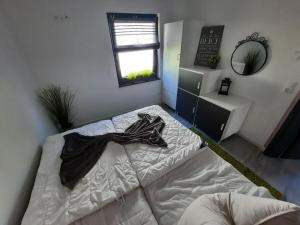 a bedroom with a bed with a black robe on it at Holiday home Zur Lenzer Höh 5 in Lenz