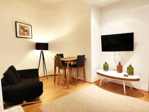 a living room with a table and a couch and a tv at Very cosy and quiet Apartment at Stadtpark in Vienna