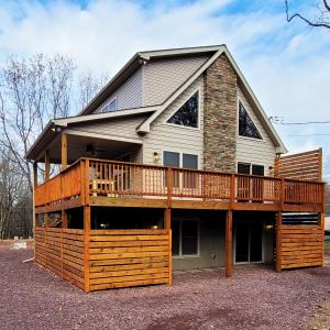 a large house with a large deck on top at Swept Away Chalet - Luxurious NEW 6 BR Home Sleeps 16 Hot Tub Linens and Towels in Albrightsville