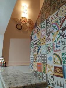 a kitchen with a wall covered in colorful tiles at Quarto Praia do Frances in Marechal Deodoro