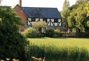 una casa en blanco y negro con un patio verde en Cider Press, en Hereford