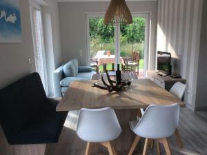 sala de estar con mesa de comedor y sillas blancas en Holiday home time out, en Petersfeld