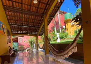 a hammock in a house with a view of a garden at Pousada Alto da Praia in Arraial d'Ajuda