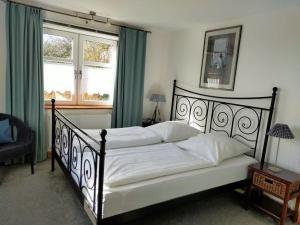 1 dormitorio con 1 cama con marco negro y 2 ventanas en Holiday home Rike, en Emmelsbüll-Horsbüll
