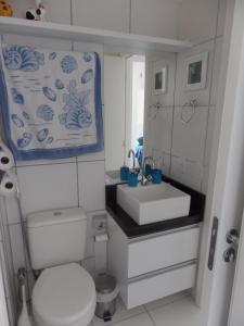 a bathroom with a white toilet and a sink at Mediterrane Residence in Aquiraz