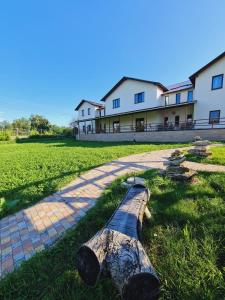 ein auf dem Gras vor einem Gebäude liegendes Blockhaus in der Unterkunft Pensiunea turistică MUZE in Rezina