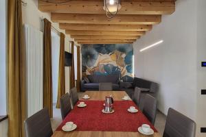 a dining room with a table and a couch at La Maison de Joanna 3 in Châtillon