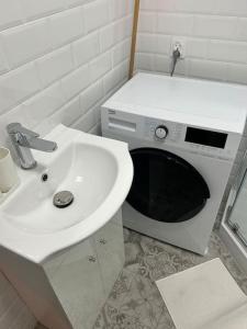 a bathroom with a sink and a microwave at Klimatyczne gniazdko przy Rynku in Wrocław
