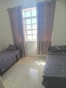 - une chambre avec 2 lits et une fenêtre dans l'établissement Apartamento de 2 pisos en Porlamar, à Porlamar