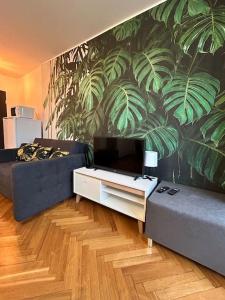 a living room with a couch and a wall with plants at Klimatyczne gniazdko przy Rynku in Wrocław