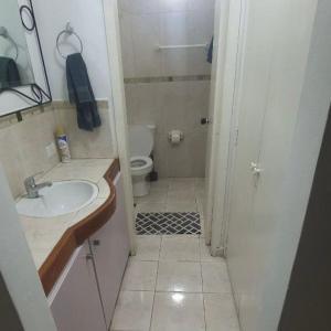 La petite salle de bains est pourvue d'un lavabo et de toilettes. dans l'établissement Apartamento de 2 pisos en Porlamar, à Porlamar