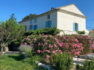 una casa con flores rosas delante de ella en Le vieux Bounias, en Carpentras