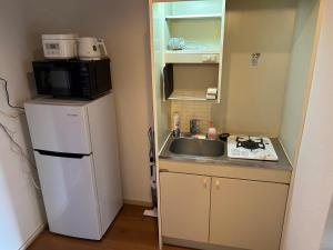 Il comprend une petite cuisine équipée d'un évier et d'un four micro-ondes. dans l'établissement ＴＡＪＩＭＡ ＢＡＳＥ - Vacation STAY 16243, à Fukuoka