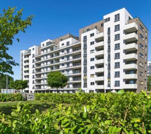 dos altos edificios blancos en un parque con arbustos en Magnifique appartement 2 chambres à Liège Ougrée en Seraing
