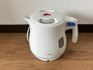 a white electric kettle sitting on a wooden table at ＴＡＪＩＭＡ ＢＡＳＥ - Vacation STAY 16243 in Fukuoka