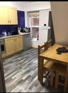 a kitchen with a wooden table and a kitchen with a sink at Eden Rose Cottage in Morecambe