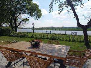 a wooden table with chairs and a bowl of flowers on it at Holiday home at the end of the Weser in Dörverden