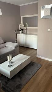 uma sala de estar com um sofá e uma mesa de centro em Apartament Szarotki em Szczecin