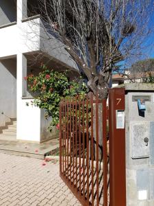 um portão de madeira em frente a uma casa com uma árvore em Villino Lucy centro paese em Vetralla