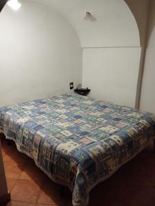 un letto in una stanza con una trapunta sopra di Il nido delle aquile a Pantelleria