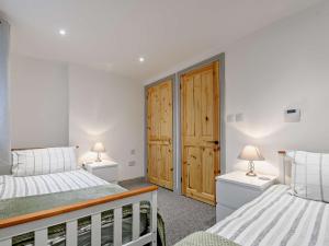 een slaapkamer met 2 bedden en 2 lampen op tafels bij 2 Bed in Gloucester 91603 in Matson
