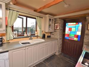 eine Küche mit einem Waschbecken und einem Buntglasfenster in der Unterkunft 3 Bed in Padstow 51214 in Padstow