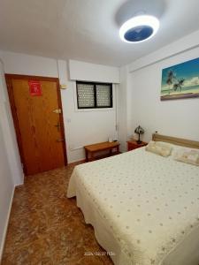 een slaapkamer met een bed en een houten deur bij Apartamento MIRAMAR in Torrevieja