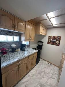 a kitchen with wooden cabinets and a counter top at Blue House in Sylvan Lake