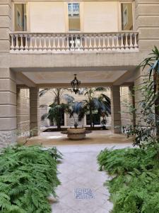 un grand bâtiment avec une cour plantée de palmiers dans l'établissement Tamborino Balcony Apartment - Salento Apartments Collection, à Lecce
