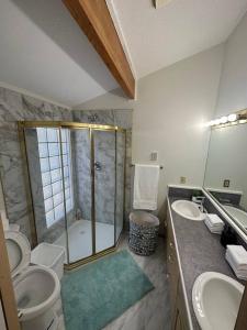 a bathroom with a shower and two sinks and a toilet at Blue House in Sylvan Lake