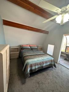 a bedroom with a bed and a ceiling fan at Blue House in Sylvan Lake