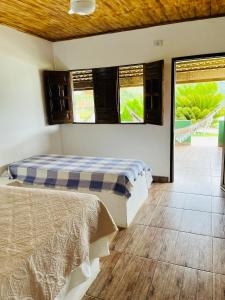 two beds in a room with two windows at Pousada e Restaurante Alto da Serra in Bonito