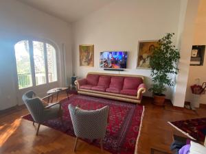 sala de estar con sofá rojo y sillas en VILLA TARA, en Quercianella