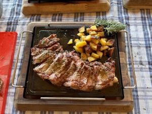 a plate of meat and potatoes on a table at Agriturismo del Sole in Anacapri