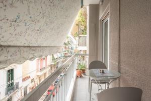 - un balcon avec une table et des chaises dans un bâtiment dans l'établissement Cozy Athens Apartment, à Athènes