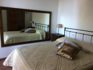 a bedroom with two beds and a large mirror at Agriturismo del Sole in Anacapri