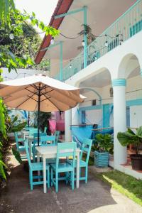 Hostal Eden في مويوجالبا: طاولة وكراسي مع مظلة أمام المبنى
