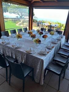 a long table with plates and glasses and flowers on it at Agriturismo del Sole in Anacapri