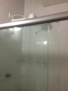 um chuveiro com uma porta de vidro na casa de banho em Hotel Gaivota no Recife