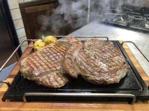 dois pedaços de carne numa grelha num fogão em Agriturismo del Sole em Anacapri