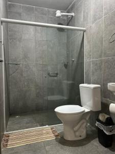 a bathroom with a toilet and a glass shower at Pousada e Restaurante Alto da Serra in Bonito