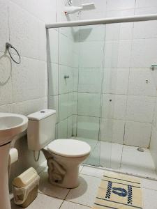 uma casa de banho com um WC e uma cabina de duche em vidro. em Pousada e Restaurante Alto da Serra em Bonito