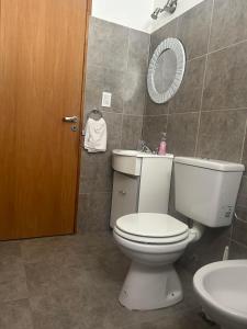 a bathroom with a toilet and a sink and a mirror at La Juana in Esquel +9 photos