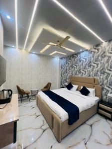 a bedroom with a bed and a table and chairs at Crescent Inn in Greater Noida