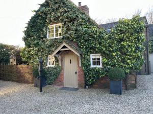 a brick house with a white door at Well house in Stone