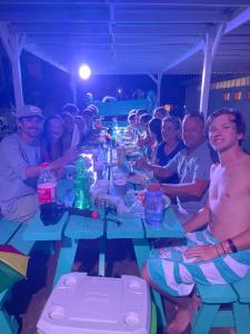 a group of people sitting around a long table at Royal Rat Hostel in Placencia +108 photos