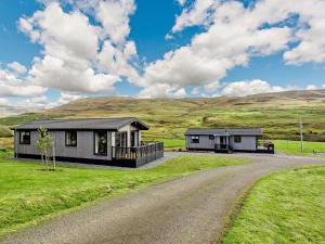 uma casa numa colina com uma estrada de terra em 2 Bed in Isle of Skye 75068 em Portree
