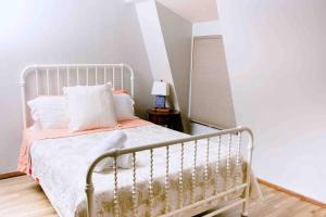 um quarto com uma cama de metal com almofadas brancas em The Lodge on Gray House Farm em Hulbert
