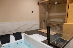 a bathroom with a tub and a shower at AETERNA SUITES SPA Apartment in Terracina