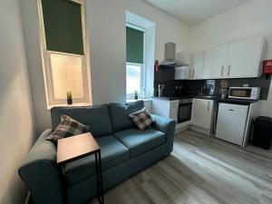a living room with a couch and a kitchen at Carmen Sylva Studio flat Llandudno sea front in Llandudno